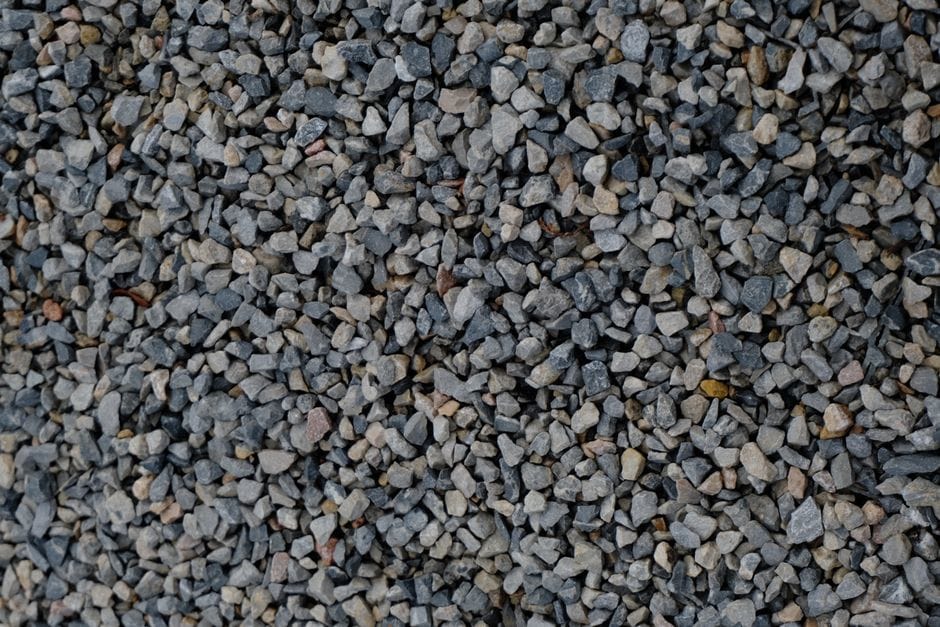 Pracownik firmy budowlanej dokładnie sprawdza frakcję kruszywa na placu budowy