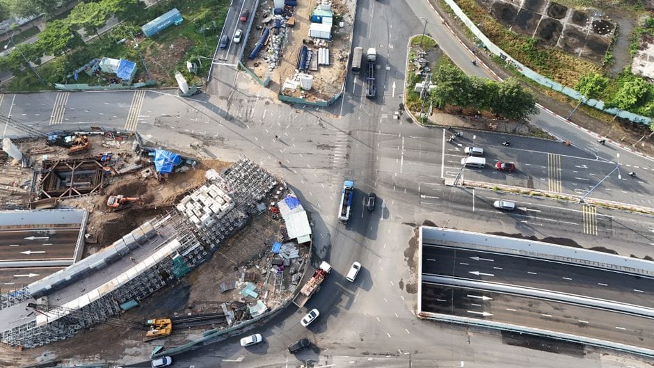 Widok na plac budowy drogi z rozłożonym kruszywem przygotowanym pod zagęszczanie