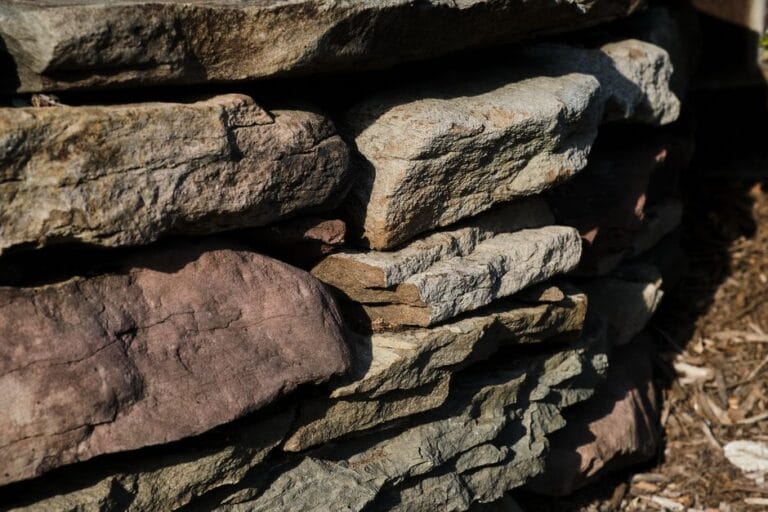 Proces układania kruszywa pod fundament schodów ogrodowych z wykorzystaniem ciężkiego transportu
